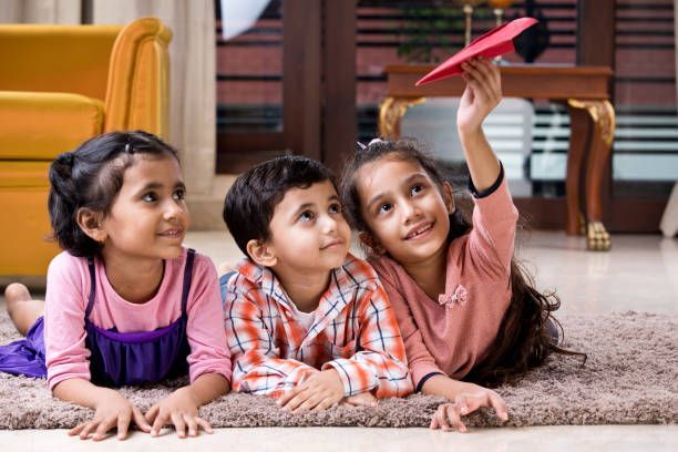 Happy children playing with toy paper airplane on carpet at home Your Child will Become More Active